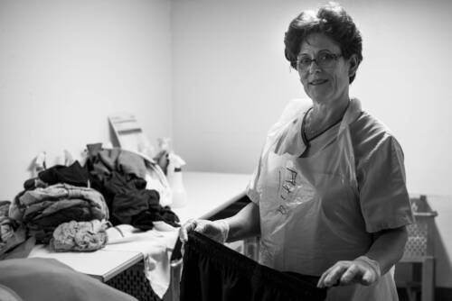 Une des membres de l'intendance qui plie du linge