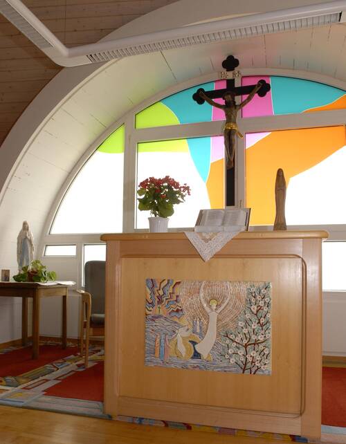 L'oratoire des Planchettes en premier plan et une croix chrétienne en arrière-plan